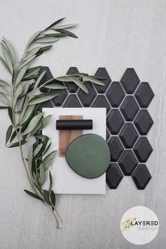 an overhead view of various items on a white surface with green leaves and grey hexagonal tiles