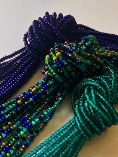 some beads are laying on top of each other and one has a green tassel