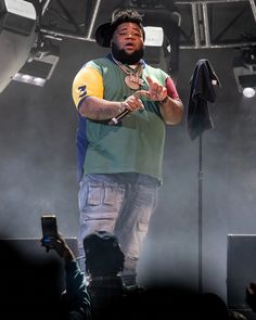 a man standing on top of a stage holding a microphone