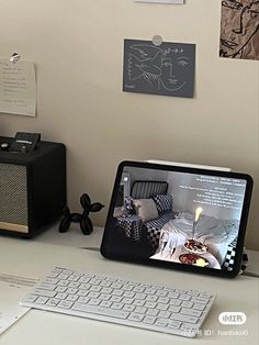 an ipad is sitting on a desk next to a keyboard