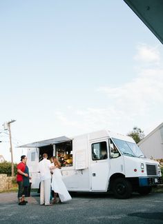 a group of people standing in front of a food truck