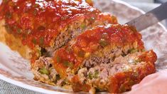 the meatloaf is covered with sauce and green peppers on it's side