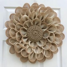 a large flower made out of jute burlocks on a white front door