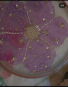 an artistically designed glass plate with gold and purple flowers on it's surface