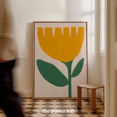 a large yellow flower sitting on top of a black and white checkerboard floor