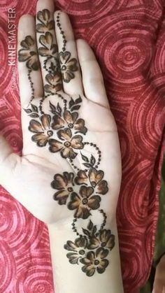 a woman's hand with flowers painted on it