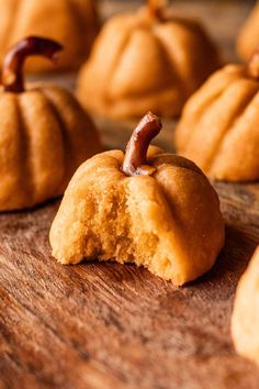 small pumpkin shaped cookies sitting on top of a wooden table