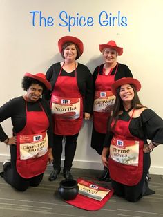 three women in red aprons and hats posing for a photo