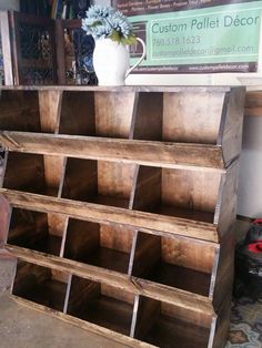 an old wooden bookcase with many compartments on it and a white vase in the background