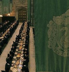 a room filled with lots of tables covered in black tablecloths and place settings