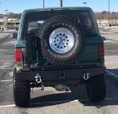 a green jeep parked in a parking lot