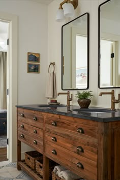 a bathroom with two sinks and mirrors on the wall