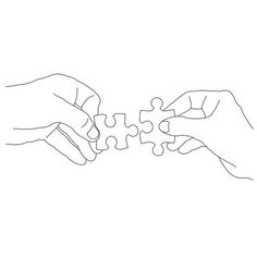 two hands holding pieces of a puzzle together