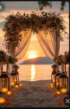 an outdoor wedding set up with candles and flowers on the beach at sunset or sunrise