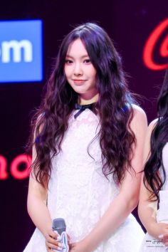 two young women standing next to each other holding microphones