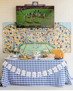 a blue and white checkered table cloth with a football game on the tv screen