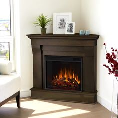 a living room with a fire place in the center and pictures on the wall above it