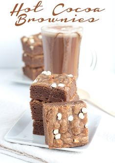 three brownies stacked on top of each other next to a cup of hot cocoa