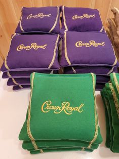 several green and purple bags sitting next to each other on a white tablecloth with gold lettering