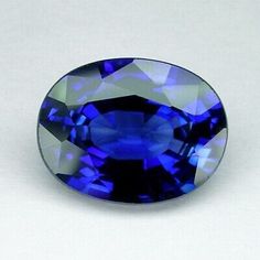 an oval blue sapphire stone on a white background