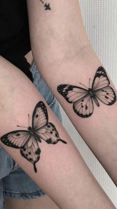 two butterfly tattoos on both arms, one is black and the other has white butterflies