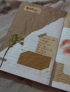 an open book with torn paper and flowers on it