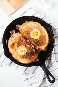 two fried eggs are in a pan on a towel