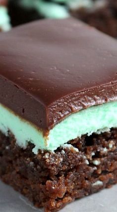 a close up of a piece of cake with chocolate and mints on the top