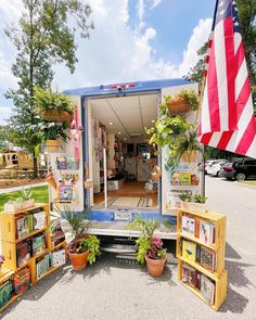 an american flag is in the back of a truck with bookshelves and potted plants