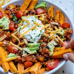 a bowl filled with taco salad and topped with sour cream