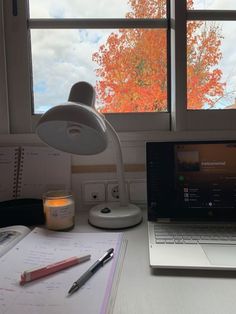 an open laptop computer sitting on top of a desk next to a cup and pen