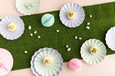 paper flowers are laid out on the grass with eggs and shells scattered around them in pastel colors