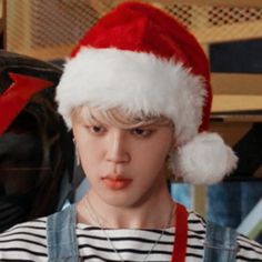 a young boy wearing a santa hat and suspenders