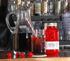 a pitcher of liquid next to two jars filled with candy canes