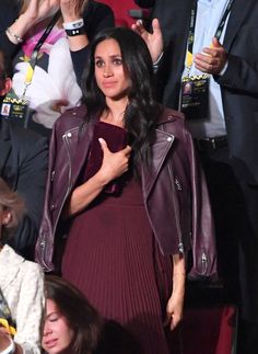 a woman in a purple dress and leather jacket