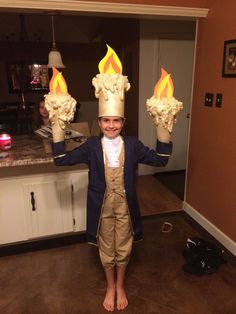 a young boy wearing a costume made to look like he is holding two torches in his hands