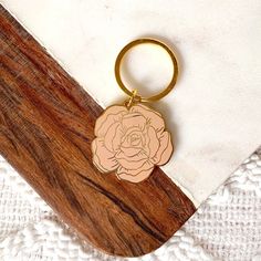 a wooden keychain with a rose on it