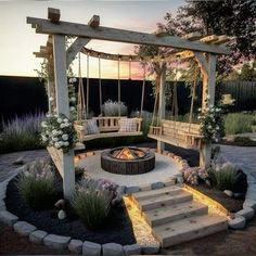 an outdoor fire pit with swings and seating