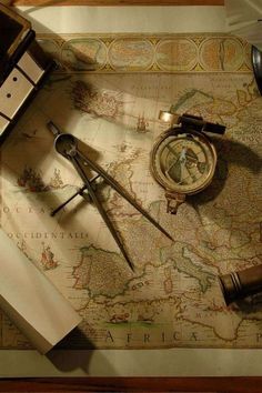 an old world map with compass, tape measure and other items on it next to a pair of scissors