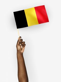 a hand holding a small black, yellow and red flag