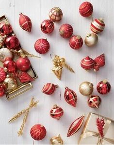 red and gold ornaments are arranged on a white table