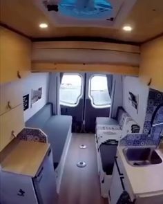 the interior of an rv with wood flooring and white appliances