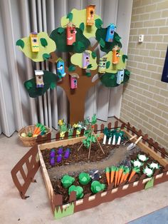 a garden with carrots, trees and paper cutouts