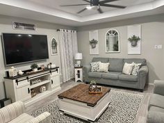 a living room filled with furniture and a flat screen tv mounted to the wall over a fireplace