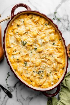 macaroni and cheese casserole in a red dish on a marble surface