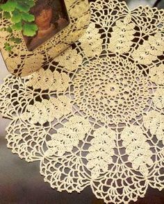 a white doily sitting on top of a table next to a potted plant