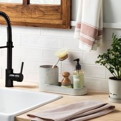 a kitchen sink with soap, brush and other bathroom items on the counter next to it