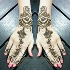 a woman's feet with henna tattoos on them and her hands showing the intricate design