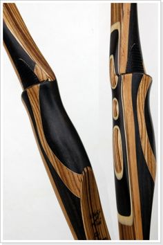 two wooden poles with black and brown designs on the top one is bent to the side