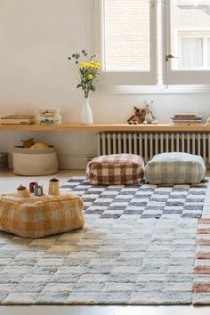 a living room filled with lots of furniture next to a window and rugs on the floor